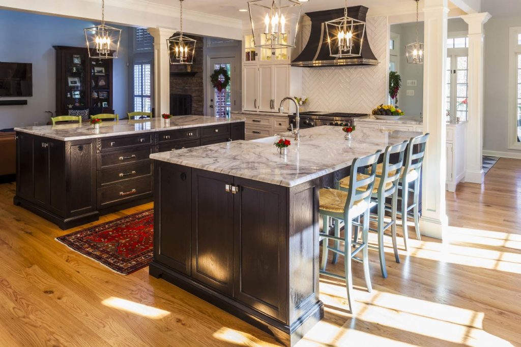 After remodeling, this kitchen blended dark and light-colored cabinets, natural wood flooring, and Quartzite countertops to create a beautiful kitchen. 