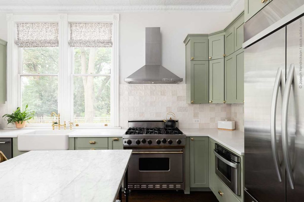 Kitchen with sage green cabinets and brass fixtures and hardware follows latest design trends